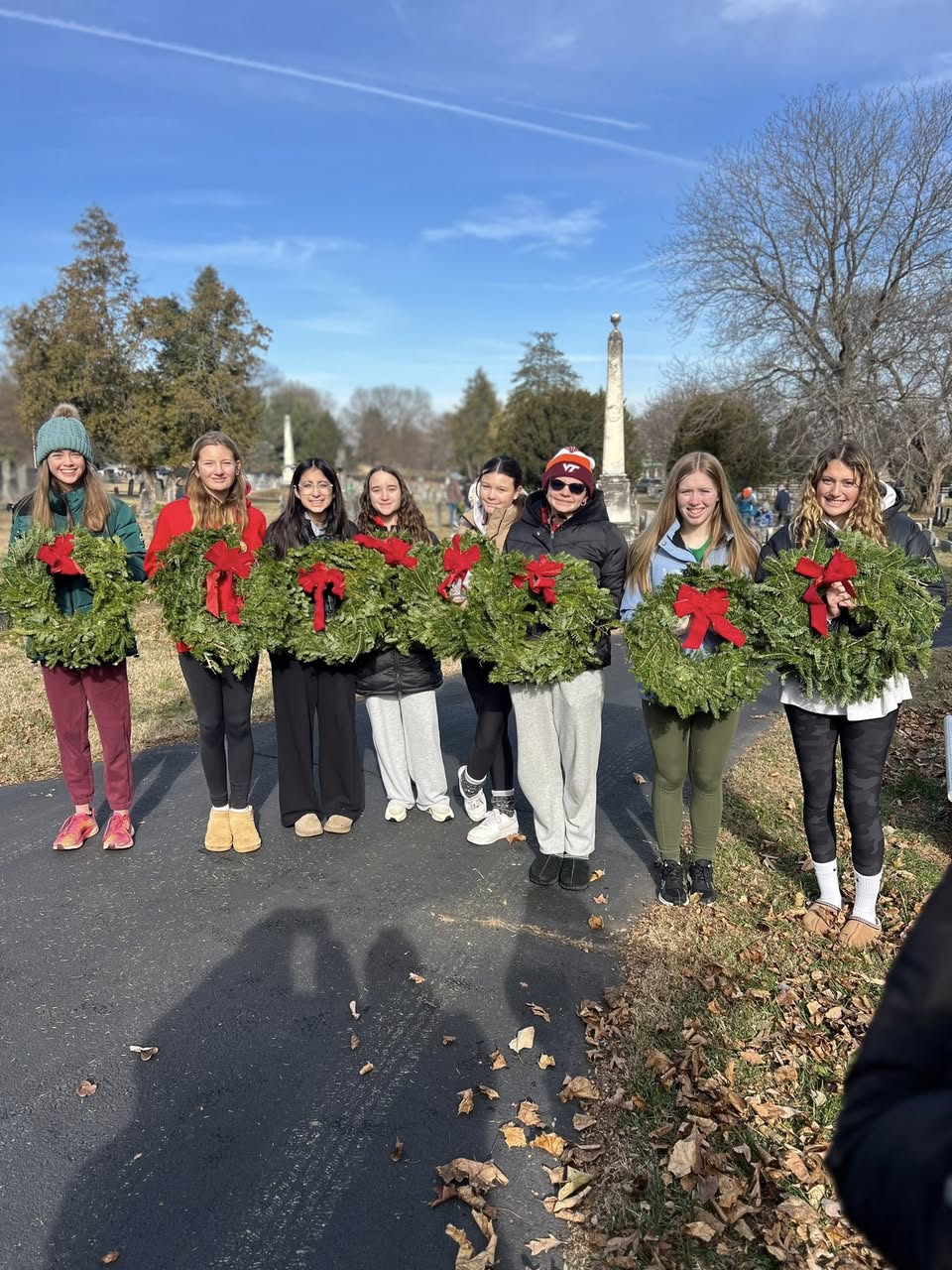 Inferno players holding remembrance wreaths at a local cemetery for Wreaths Across America